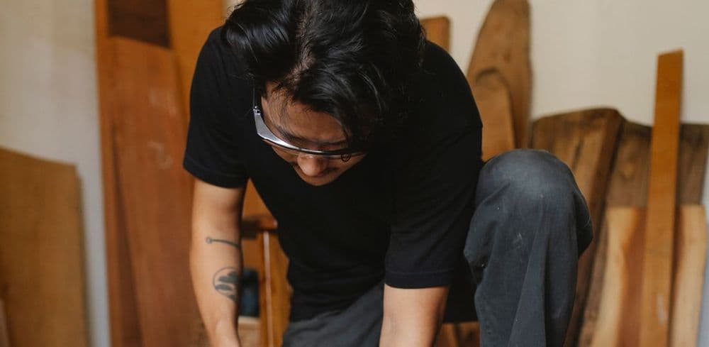 A craftsman concentrating on woodwork in his lived-in workshop